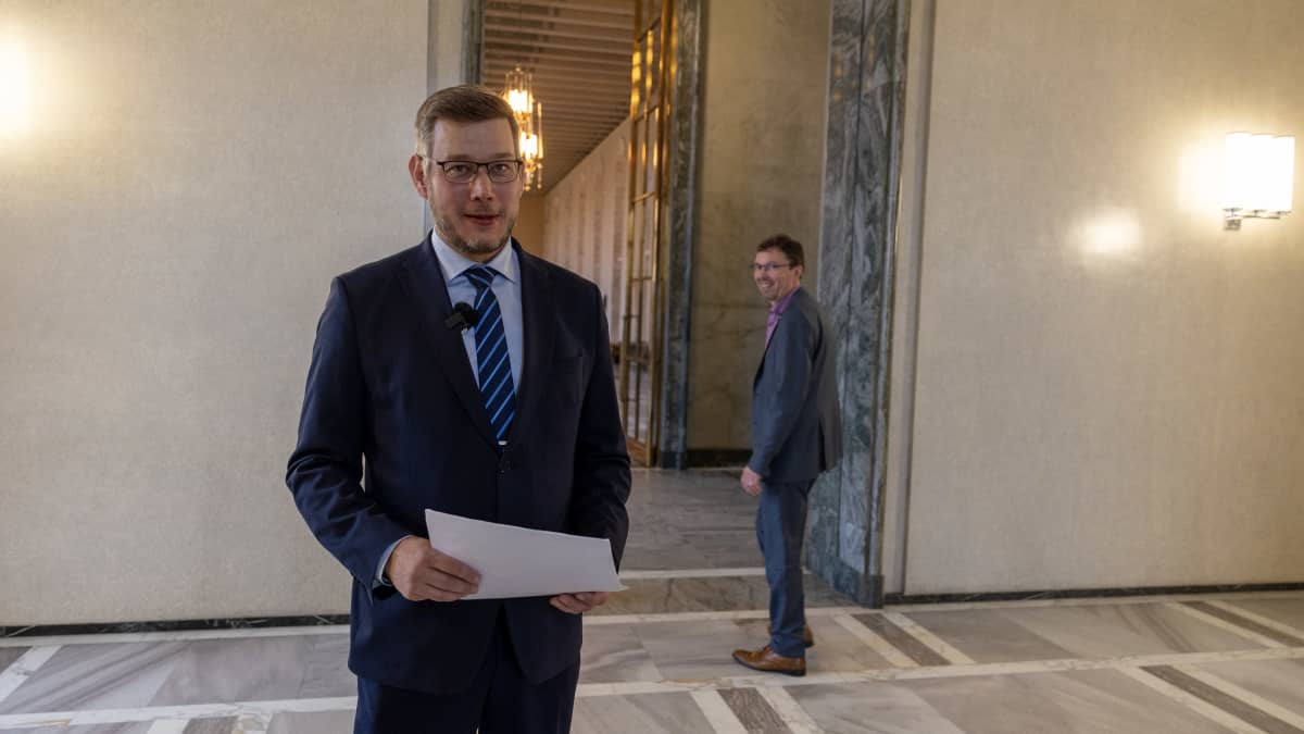 Kaksi pukumiestä, kansanedustajat Eerikki Viljanen ja Vesa Kallio, seisovat isossa aulassa.
